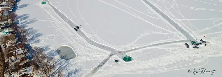 An aerial shot of a frozen lake with lanes plowed for a golf course. 