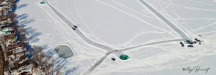 An aerial shot of a frozen lake with lanes plowed for a golf course.