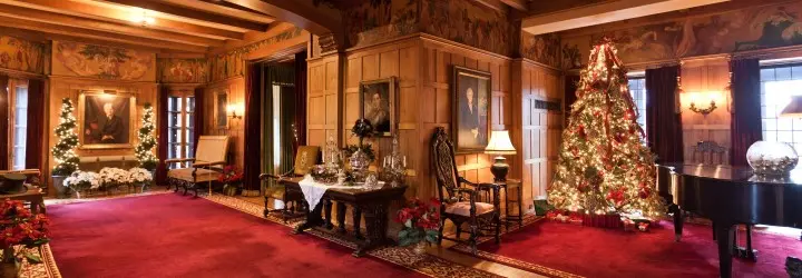 A historic room featuring red carpets and holiday decorations.