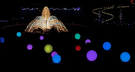 A holiday light display collection featuring colorful glowing orbs surrounding an illuminated fountain display.