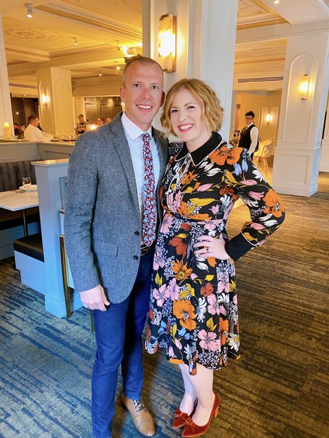 A well dressed white couple smile at the camera.