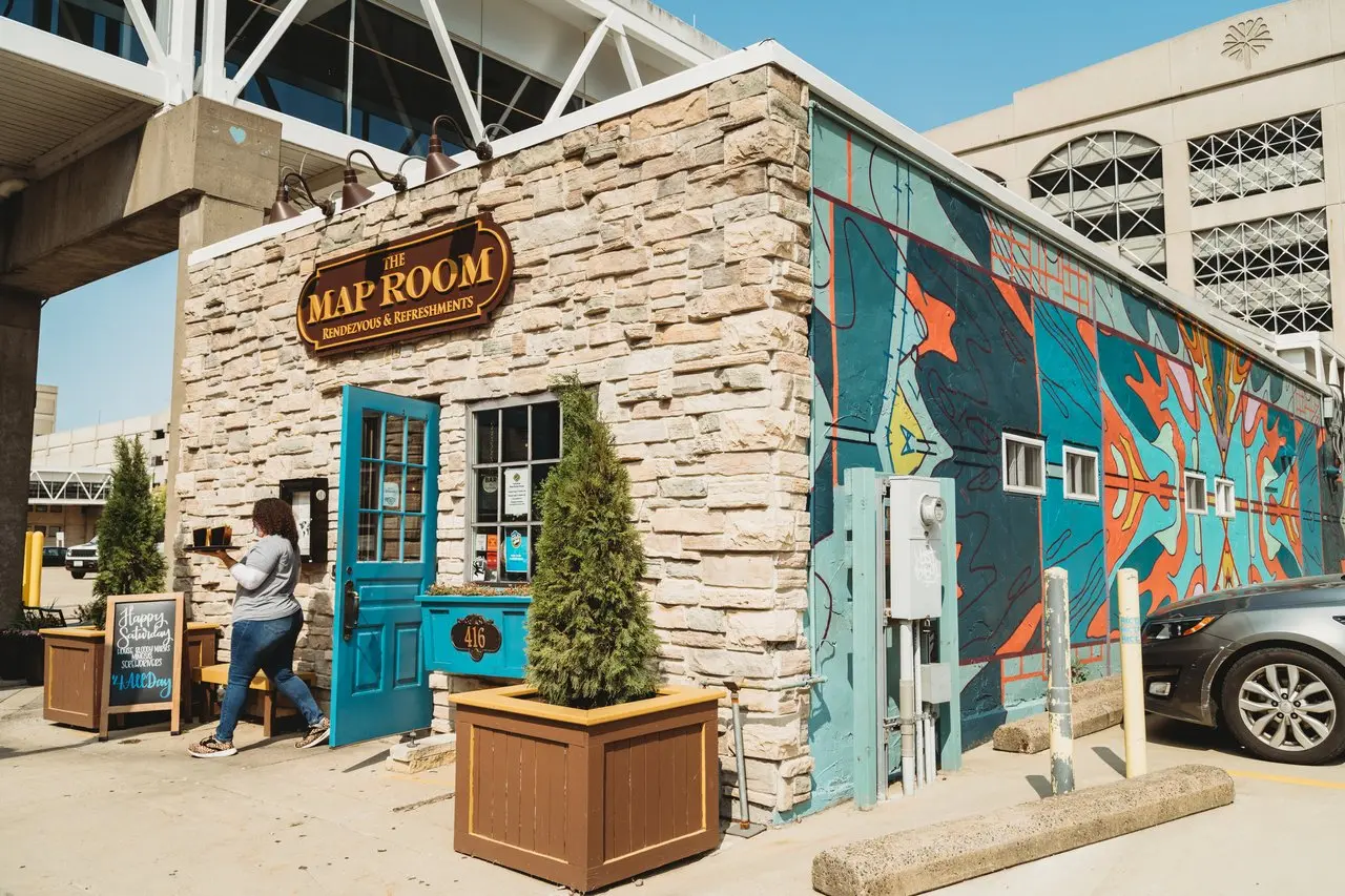 A stone building front with a vibrant mural shown on it's side.