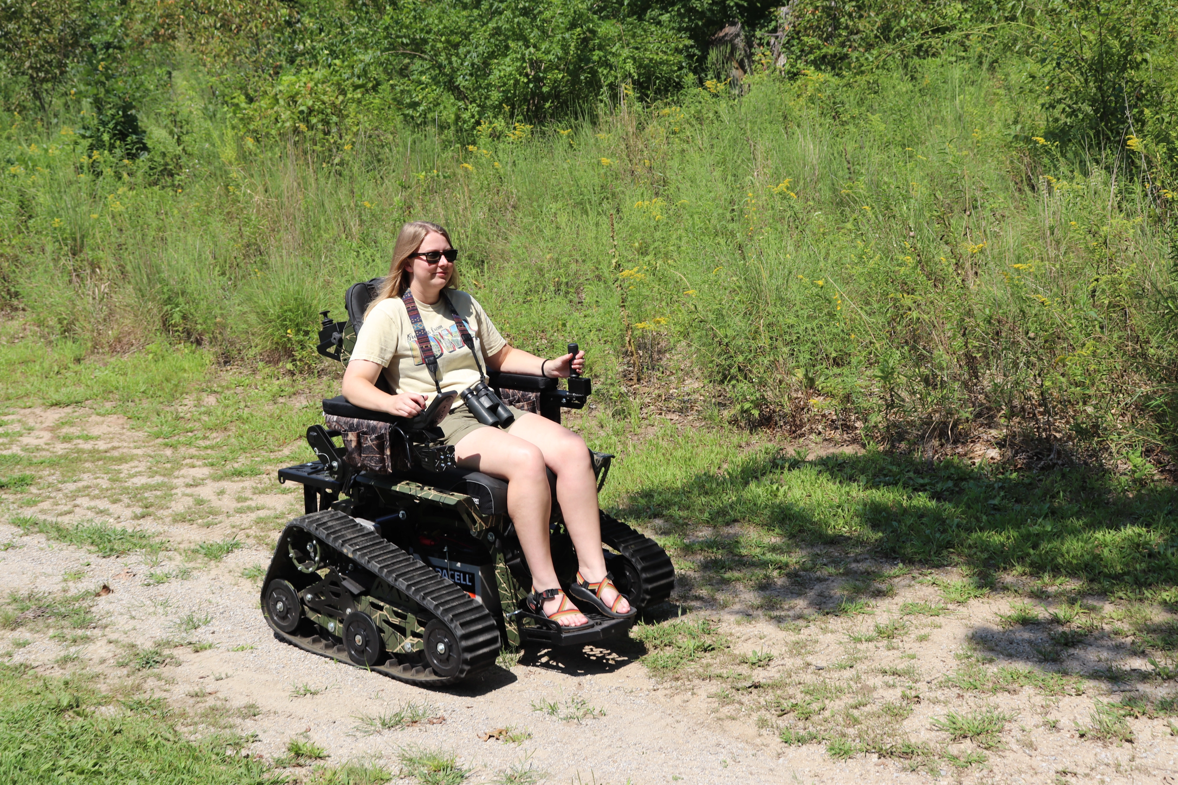 A woman traverses a gravel trail in an all-terrain wheelchair.