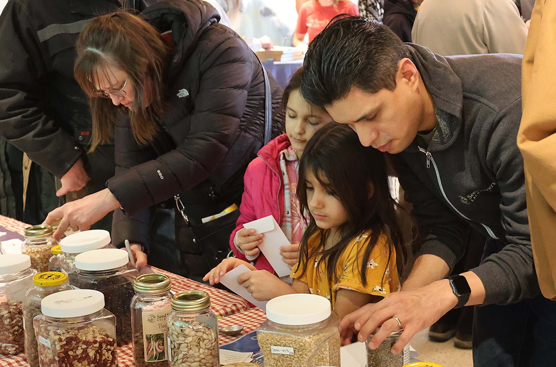 A family selects seeds at Seed Savers Exchange's national seed swap day event 2025