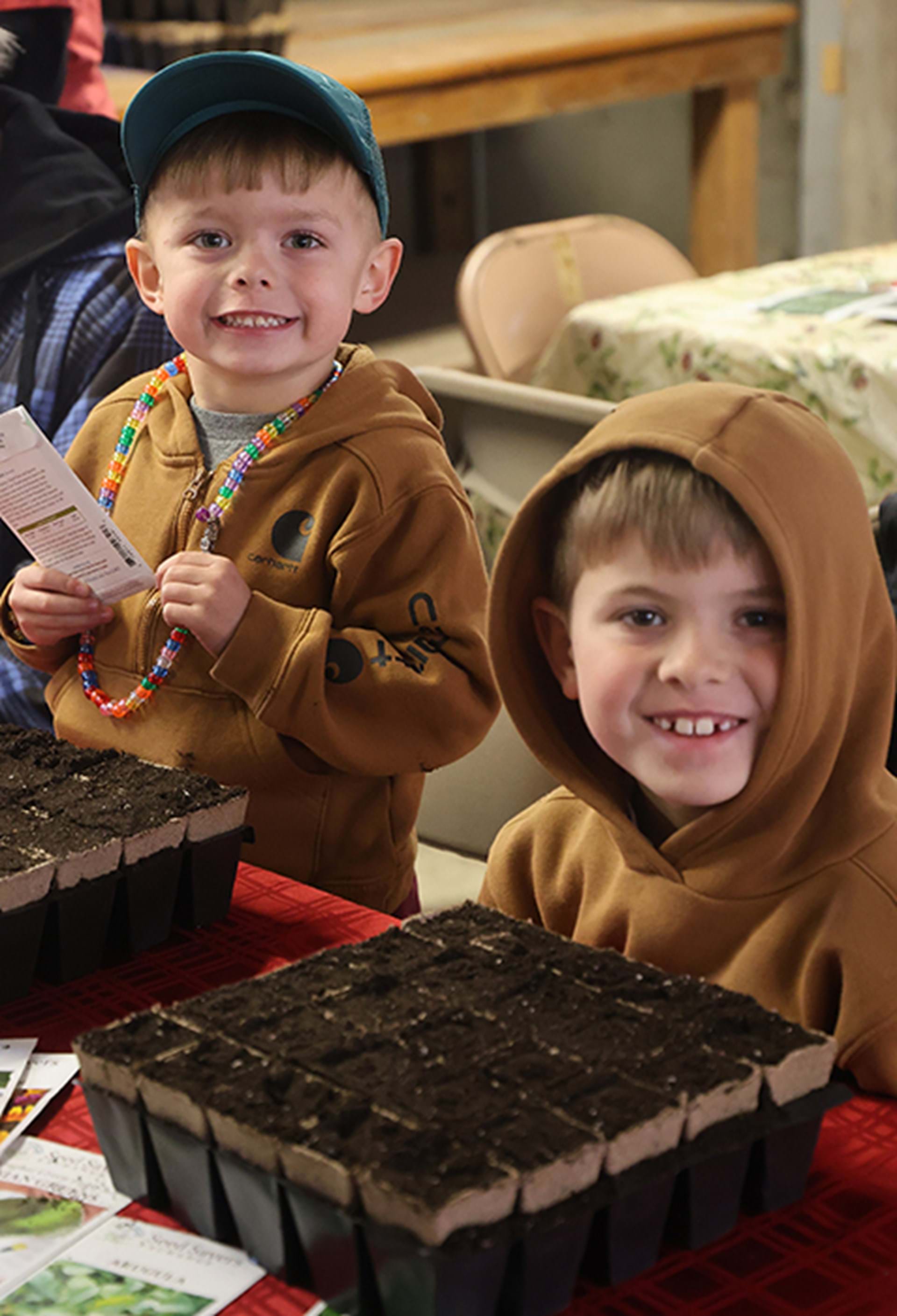 Two happy seed starting workshop participants smile to camera.