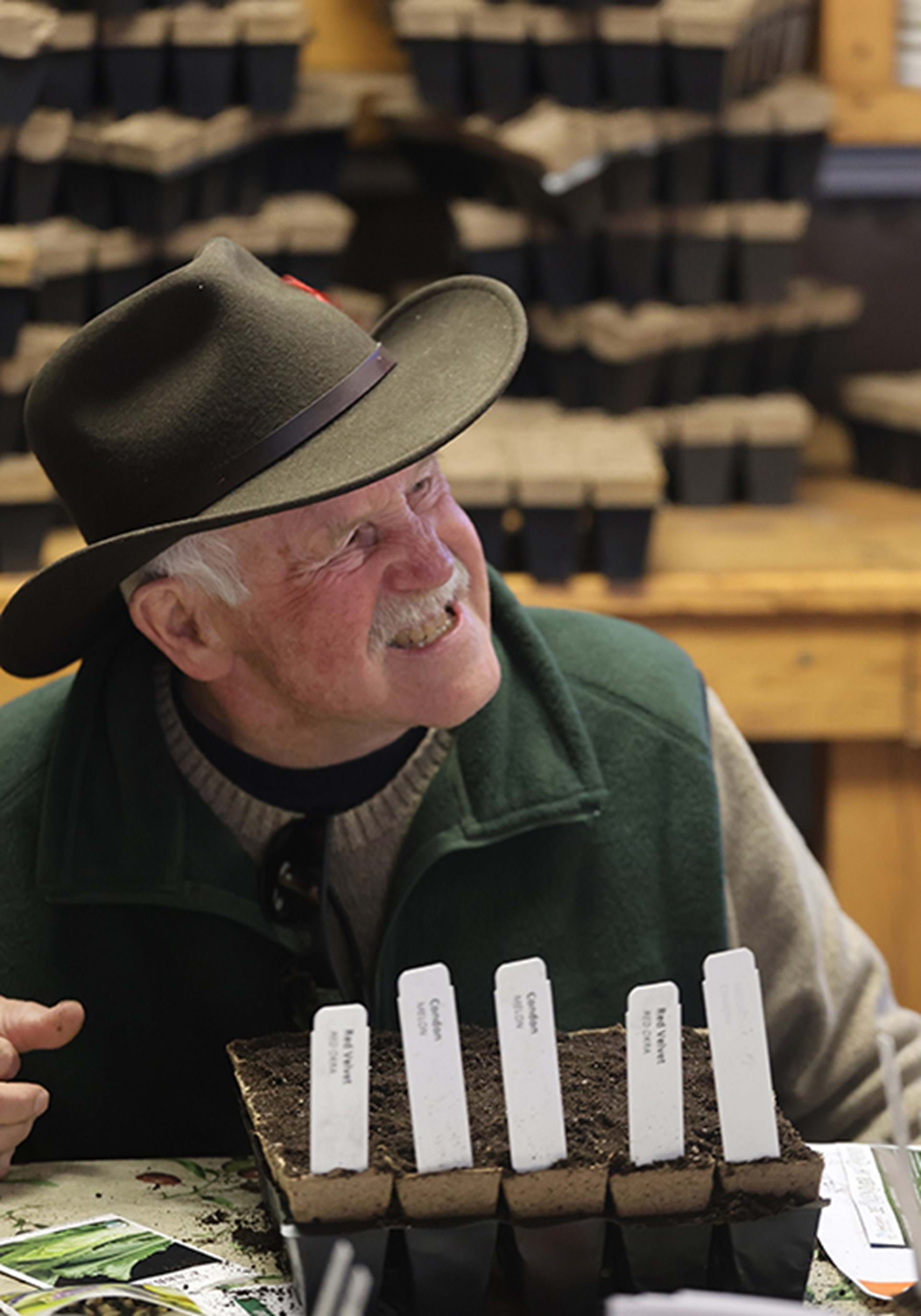 One seed starting workshop participant from 2025 smiles with his seeded pots.