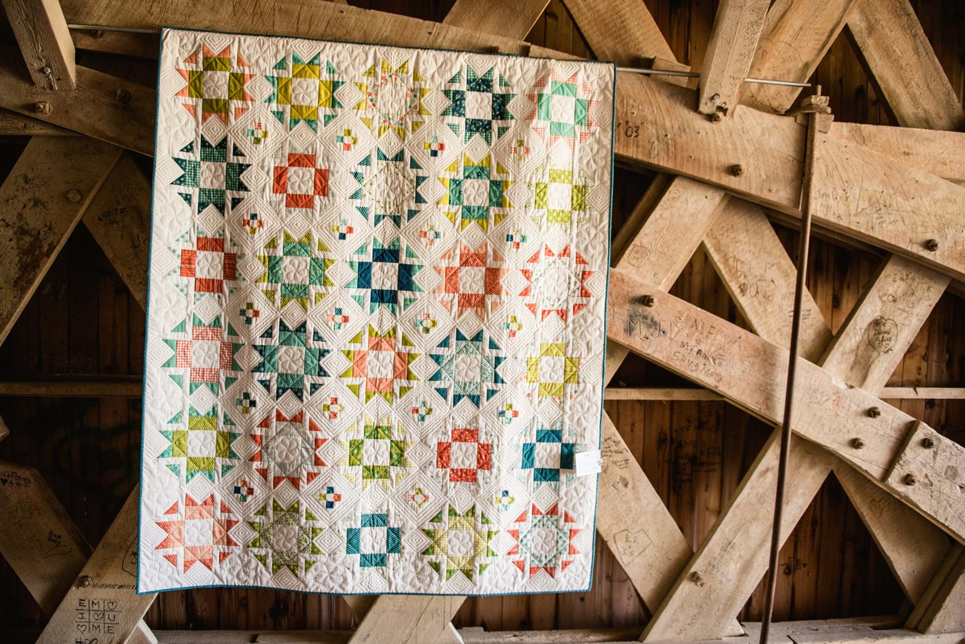 A quilt hanging on a covered bridge