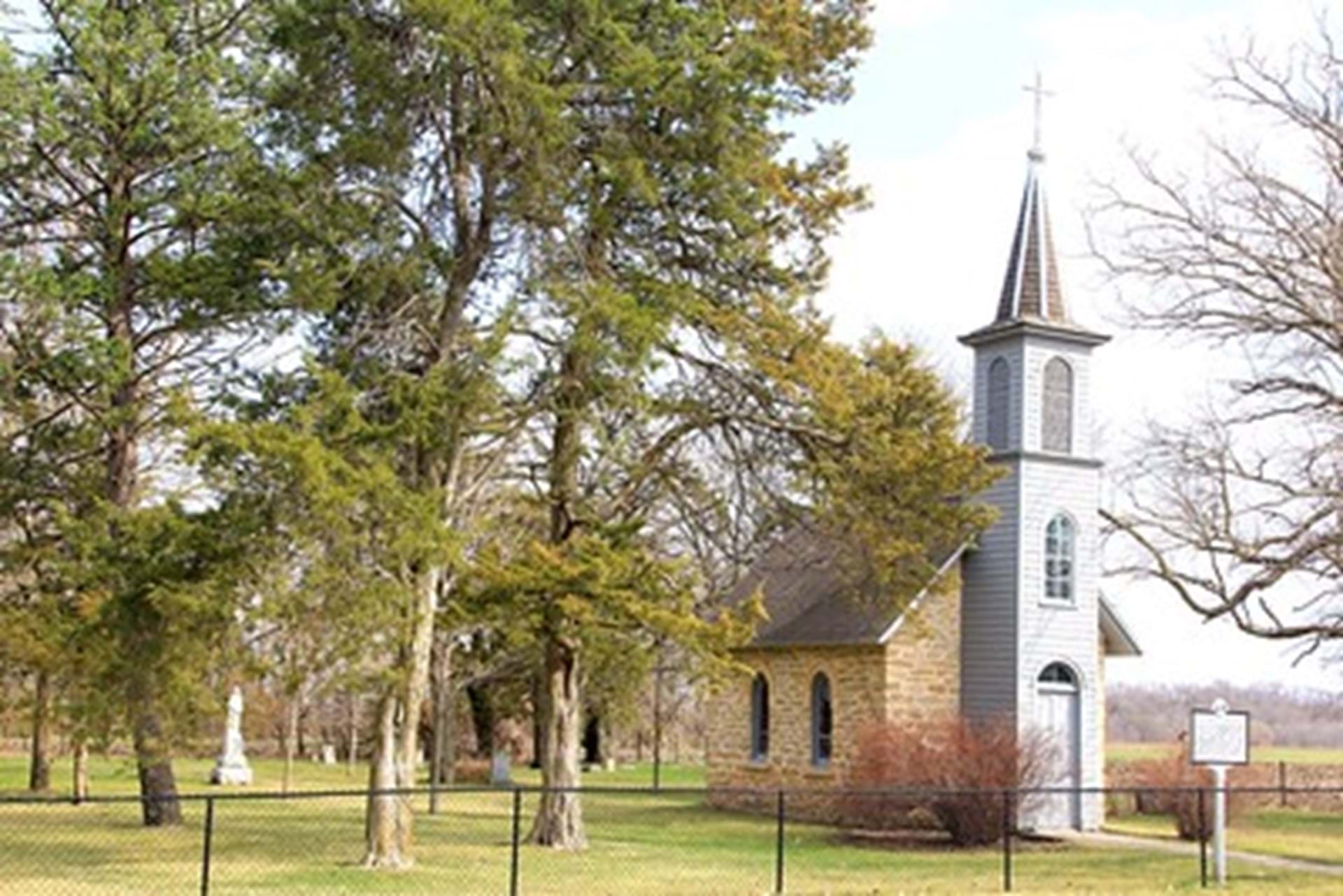 The smallest church tucked behind a couple trees