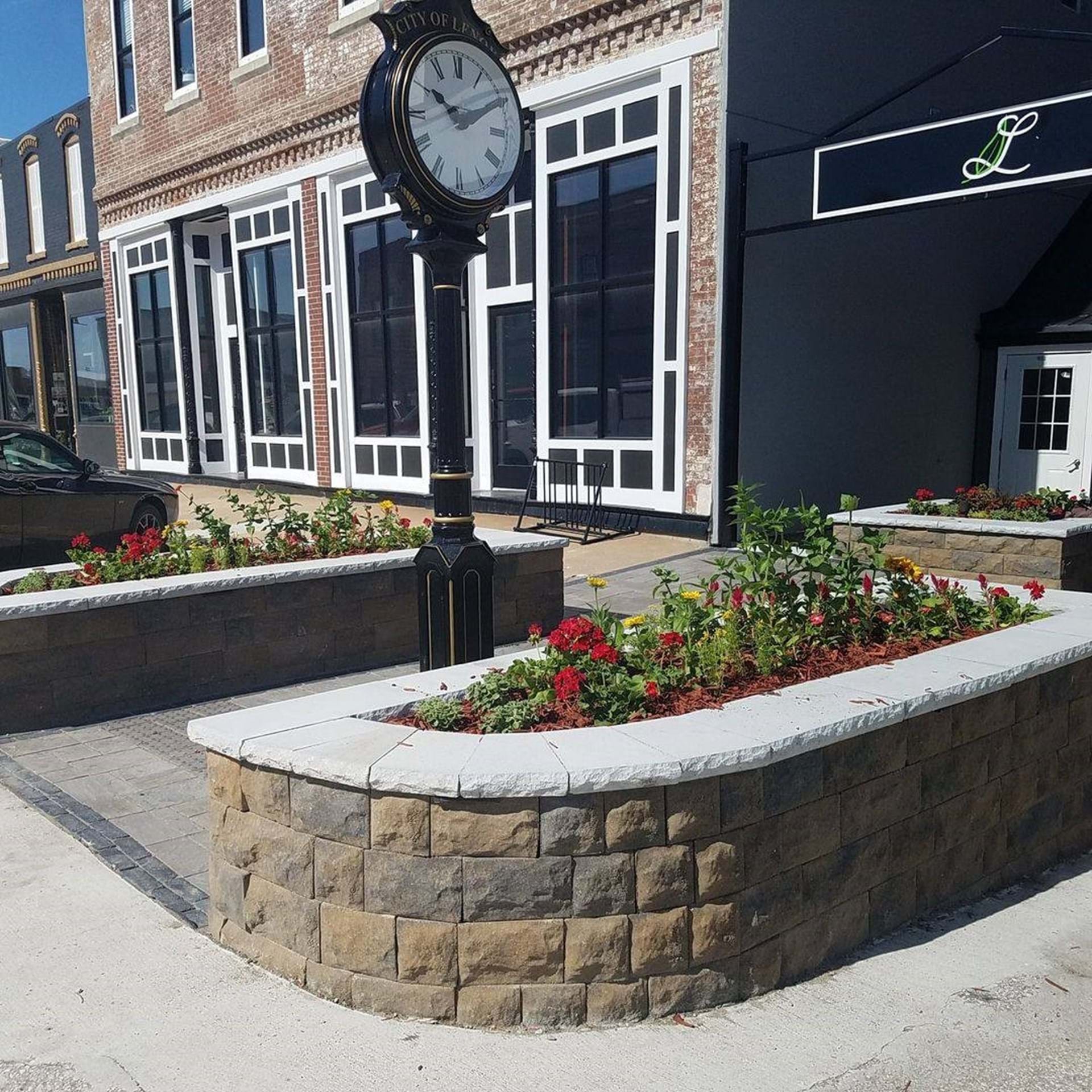 Vintage-style clock sits between the curb bump-out planters