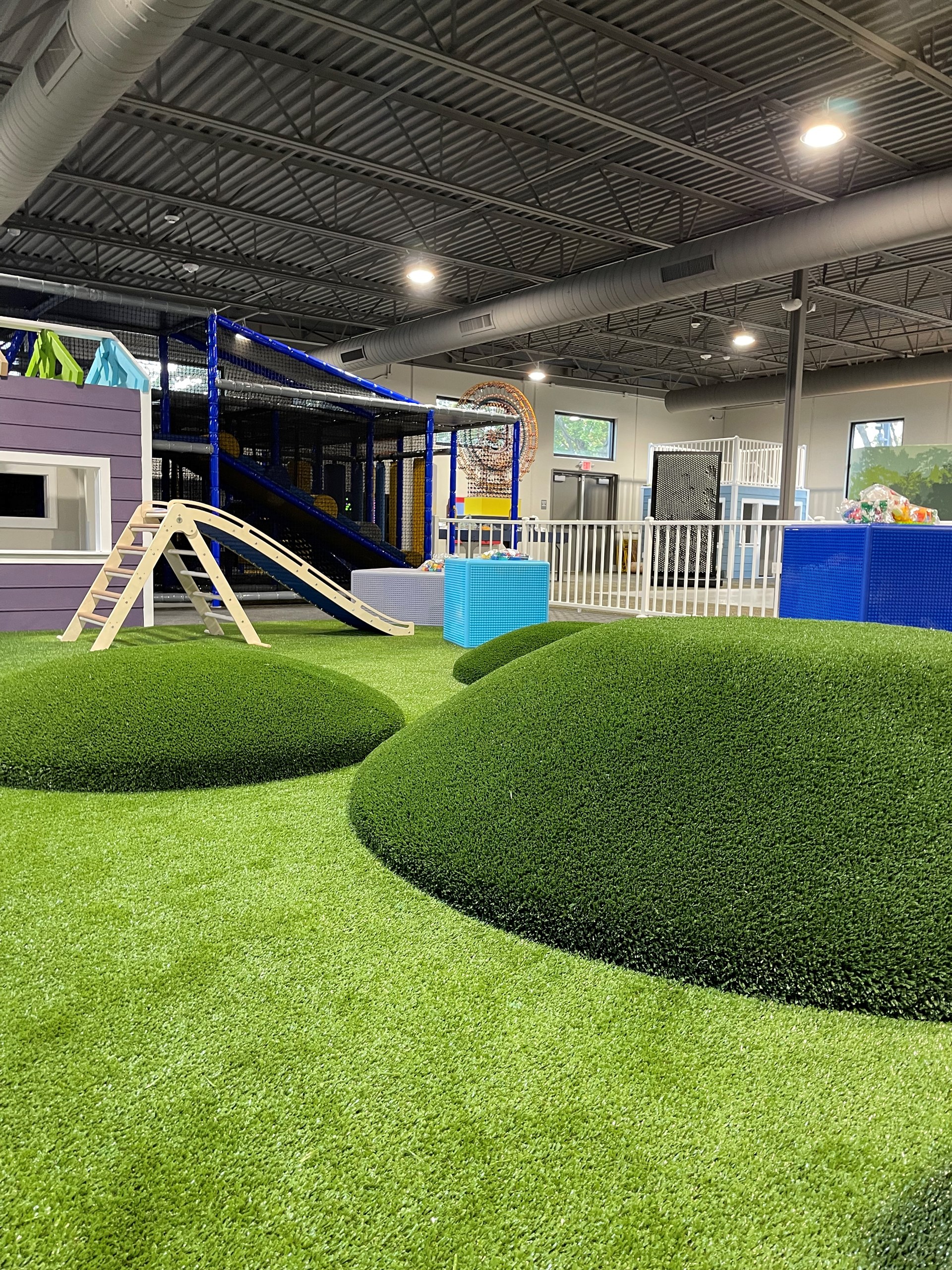 Toddler play area with soft turf and climbing mounds