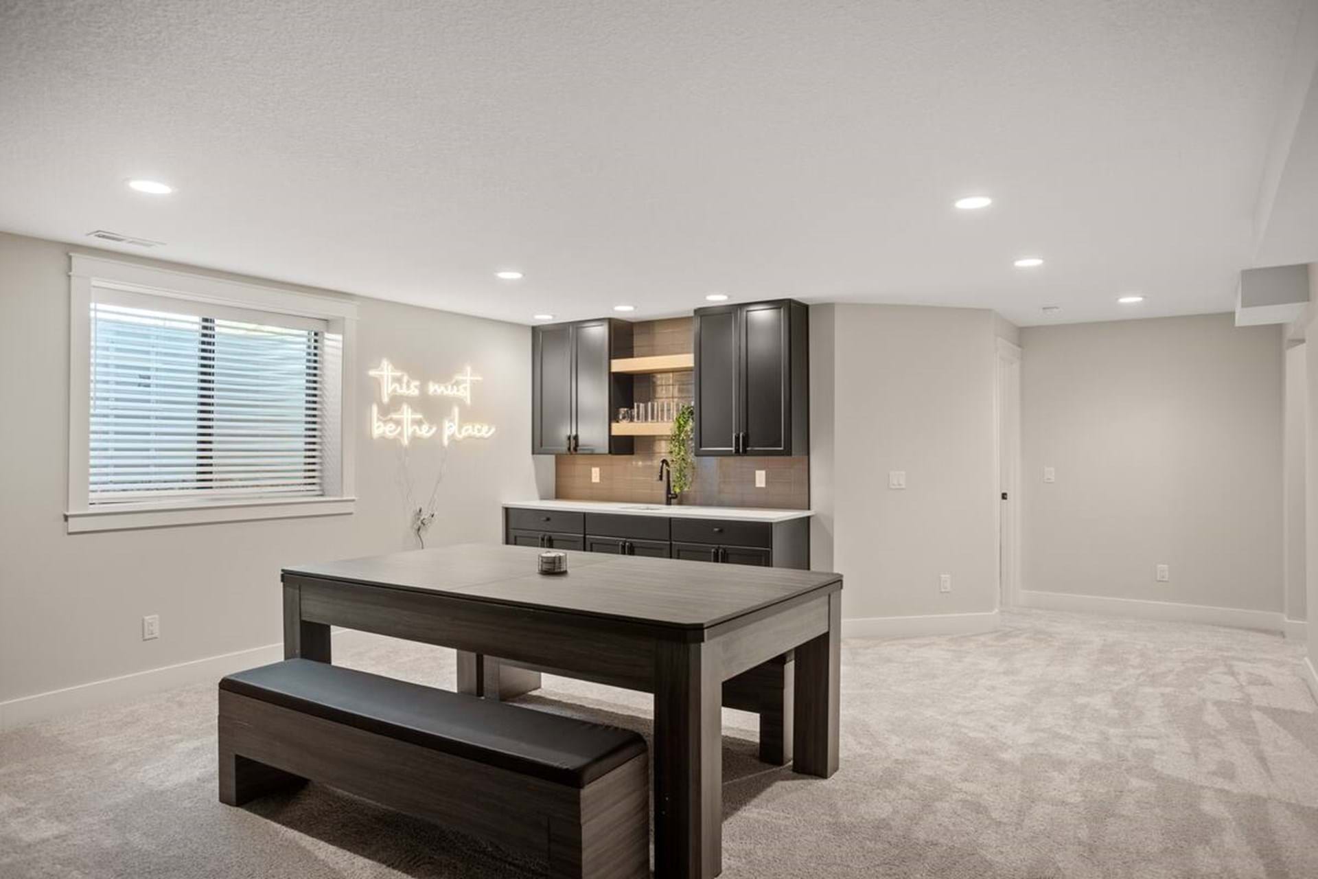 Lower-level lounge with dining space and a bar area, perfect for groups